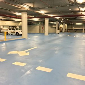 Underground car park with clearly marked parking bays, directional arrows,vensuring safe traffic flow and organised parking