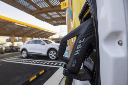 Electric car parked at a charging bay in a car park, connected to a charging station